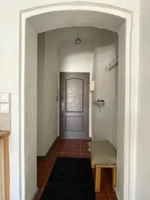 a hallway with a door and a bench and a rug at Studio avec balcon sur cour in Aix-en-Provence