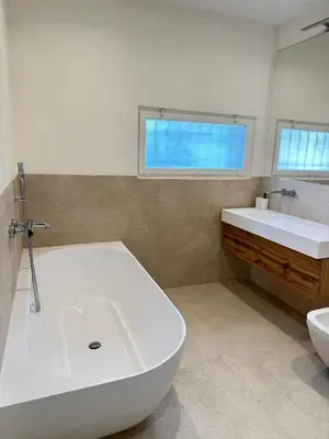 a white bathroom with a tub and a sink at Le Grand Bouteillan in Pierrevert