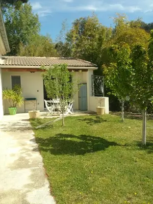 a house with a yard with a table and chairs at La Sarriette Provençale in Caumont-sur-Durance