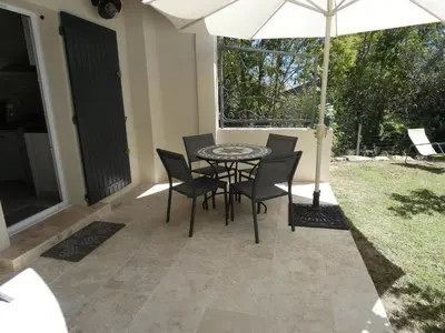 a patio with a table and chairs and an umbrella at La Sarriette Provençale in Caumont-sur-Durance