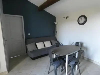 a table and chairs in a room with a couch at La Sarriette Provençale in Caumont-sur-Durance
