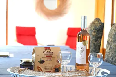 a bottle of wine and two wine glasses on a table at Le Jardin d'Auguste in Roussillon