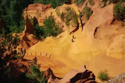 a painting of a person riding down a dirt mountain at Le Jardin d'Auguste in Roussillon