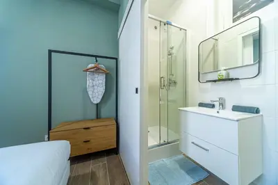 a white bathroom with a sink and a shower at Cocon T2 dans le centre d'Aix in Aix-en-Provence