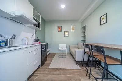 a kitchen and living room with a couch and a table at Cocon T2 dans le centre d'Aix in Aix-en-Provence