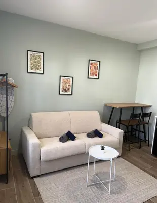 a living room with a white couch and a table at Studio raffiné - Aix hypercentre in Aix-en-Provence