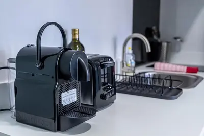 a black appliance sitting on a counter next to a sink at Studio raffiné - Aix hypercentre in Aix-en-Provence