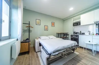 a bedroom with a bed and a kitchen at Studio raffiné - Aix hypercentre in Aix-en-Provence