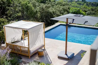 an umbrella sitting next to a swimming pool at Luxury 4-bedroom villa - pool in Gordes