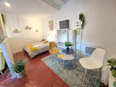 a bedroom with a bed and a table and chairs at Cosy downtown studio in Apt