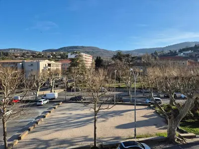 a parking lot with trees and cars in a city at Cosy downtown studio in Apt