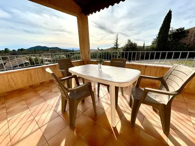 a white table and chairs on a deck with a view at Villa dans le Luberon in Saint-Saturnin-les-Apt