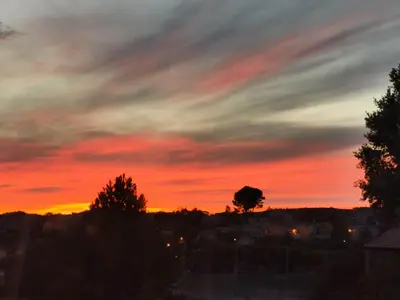 a sunset over a city with a red sky at Jolie studio en Provence! in Pierrevert