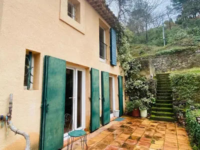 a house with a green door and a chair outside at Le Mas St Pierre in Aix-en-Provence