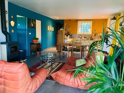 a living room with couches and a table and a kitchen at Le Mas St Pierre in Aix-en-Provence