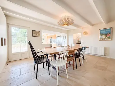 a dining room with a wooden table and chairs at Mas des Collines in Saint-Hippolyte-le-Graveyron