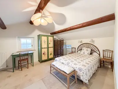 a bedroom with a bed and a table at Mas des Collines in Saint-Hippolyte-le-Graveyron