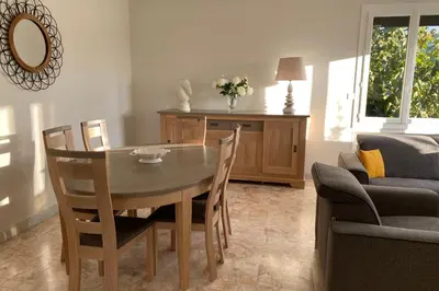 a dining table and chairs in a living room at La Maison de Gari spacious house with swimming pool and beautiful exterior in Les Taillades