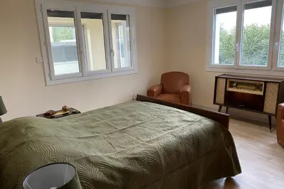 a bedroom with a bed and a chair and windows at La Maison de Gari spacious house with swimming pool and beautiful exterior in Les Taillades