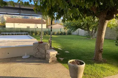 a backyard with a tree and a tennis court at La Maison de Gari spacious house with swimming pool and beautiful exterior in Les Taillades