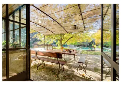 a screened in porch with a table and a bench at MAS DES CIGALES Lambesc in Lambesc
