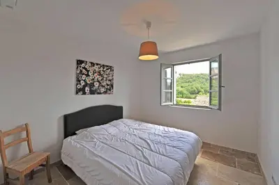 a bedroom with a bed and a window at Villa Doce Lar in Lioux