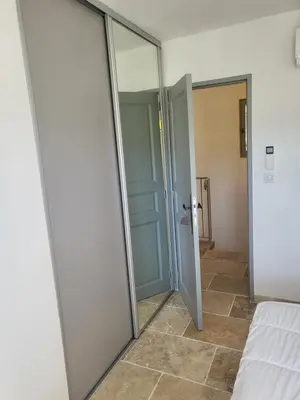 a mirrored door in a room with a bed at Villa Doce Lar in Lioux