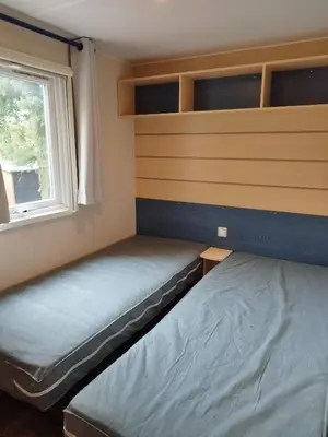 a small room with two beds and a window at Comme Chez Vous Au Camping Des Iscles in La Roque-dʼAnthéron
