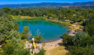 an aerial view of a lake with a playground at Comme Chez Vous Au Camping Des Iscles in La Roque-dʼAnthéron