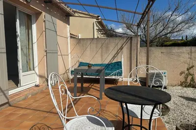 a patio with a table and chairs and a fence at At Tinou's spacious quiet house with garden for 2 people in LʼIsle-sur-la-Sorgue
