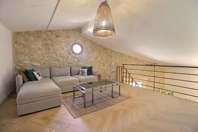 a living room with a couch and a table at Le Mas Rose Thé in Robion en Luberon