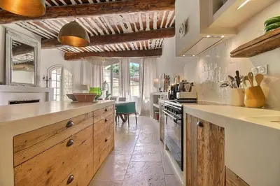 a large kitchen with wooden cabinets and a counter top at Le Mas Rose Thé in Robion en Luberon