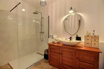 a bathroom with a sink and a shower with a mirror at Le Mas Rose Thé in Robion en Luberon