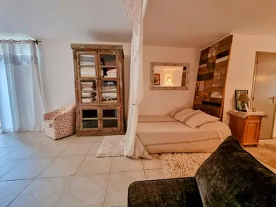 a bedroom with a bed and a couch in it at La Verrière des Songes in Robion en Luberon