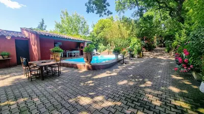 a patio with a table and a swimming pool at La Verrière des Songes in Robion en Luberon