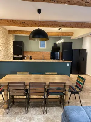 a dining room with a large wooden table and chairs at Maison du soleil in Caumont-sur-Durance
