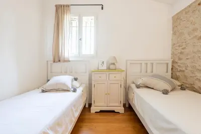 two twin beds in a room with a window at Mas de 190m2 Climatisé avec Piscine et Cuisine d'été - 10 pers in La Fare-les-Oliviers