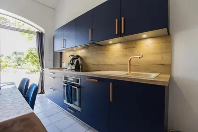 a kitchen with blue cabinets and a sink at Domaine Manon en Luberon privatisé - 22 couchages in Lagnes