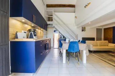 a kitchen with blue cabinets and a table with blue chairs at Domaine Manon en Luberon privatisé - 22 couchages in Lagnes