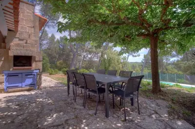 a table and chairs under a tree in a yard at Villa Martine, authentic family home in Rognes