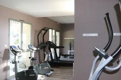 a gym with several tread machines in a room at Greens View golf saumane in Saumane-de-Vaucluse