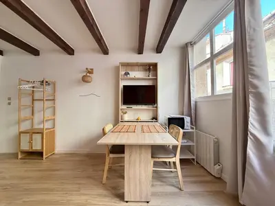 a dining room with a table and a tv at Studio lumineux centre Aix en Provence in Aix-en-Provence