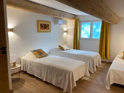a bedroom with two beds and a window at Pavillondulantana in Les Taillades