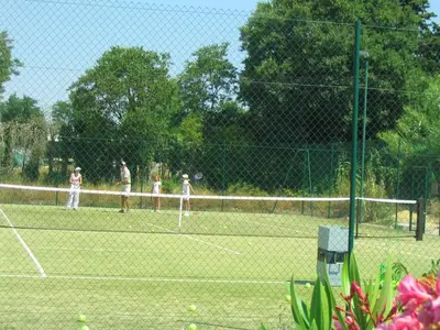 a group of people playing tennis on a tennis court at Pavillondulantana in Les Taillades
