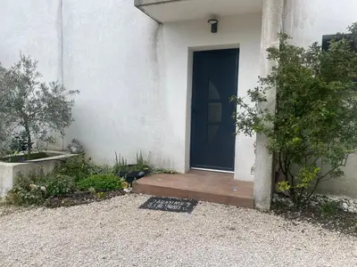 a door to a house with a cat sitting on a porch at Villa entière piscine jacuzzi venelles in Venelles