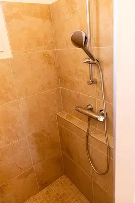 a bathroom with a round mirror and a shower at La Villa Elissia en Luberon in Saint-Saturnin-les-Apt