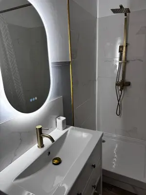 a bathroom with a sink and a mirror and a tub at Élégant T2 proche gare et centre in Miramas