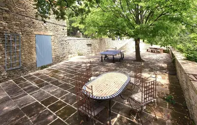 a patio with a table and chairs and a tree at Awesome Home In Goult With Wifi in Goult