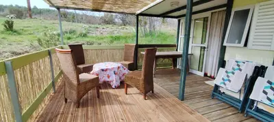 a patio with a table and chairs on a porch at Chalets dans le Luberon in Viens