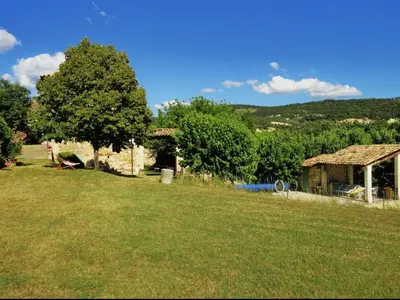 a yard with a house and a tree and grass at Domaine au cœur du Colorado Provençal in Gignac